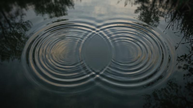 Two answers, one verdict Two sets of concentric ripples spreading across dark, still water and overlapping in the middle